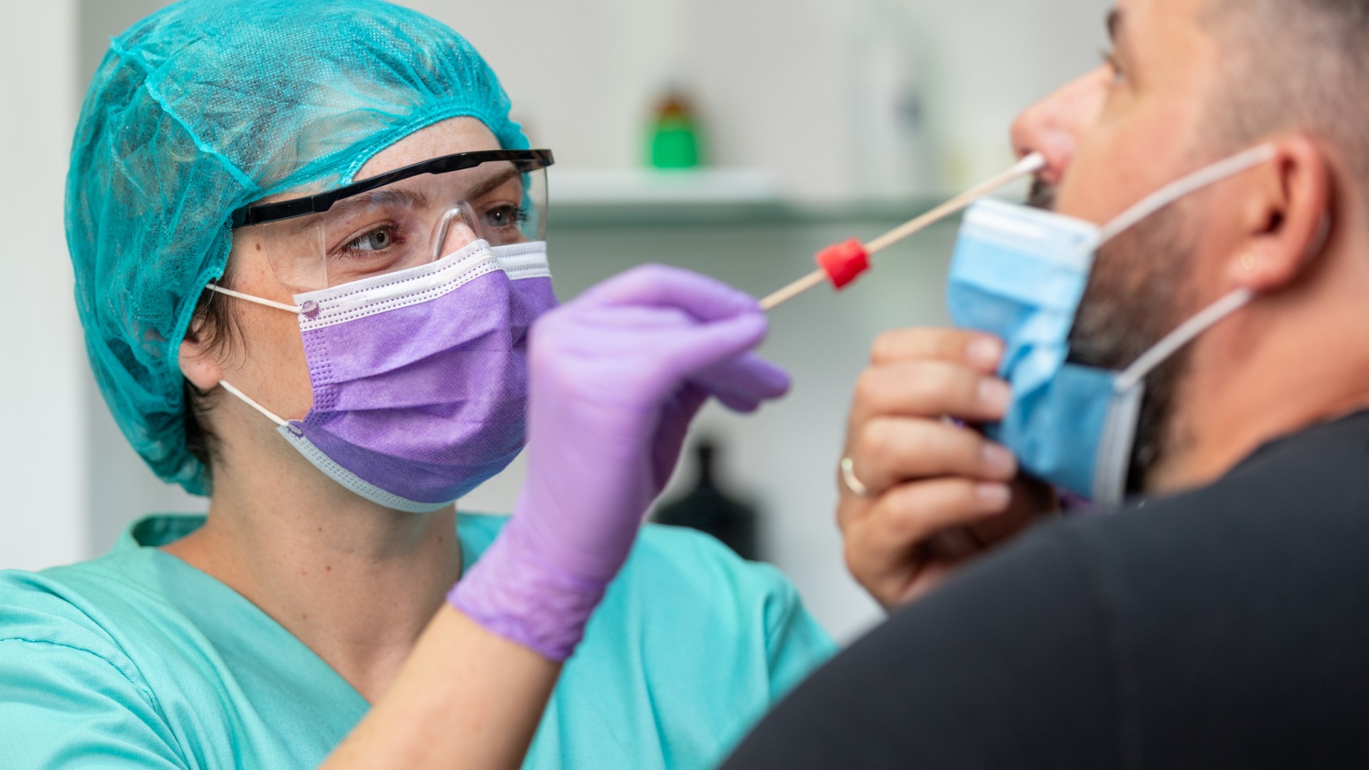 female-doctor-in-protective-workwear-taking-nose-swab-test-from-mid-picture-id1226005038